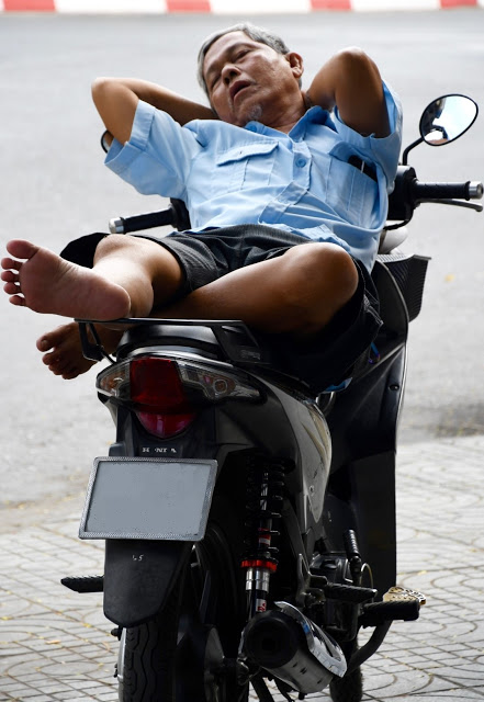 side walk tired motor driver sleeping voetpad Saigon Ho Chi Minh City Vietnam